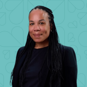 Lauren Reyes-Grange headshot on a teal background.