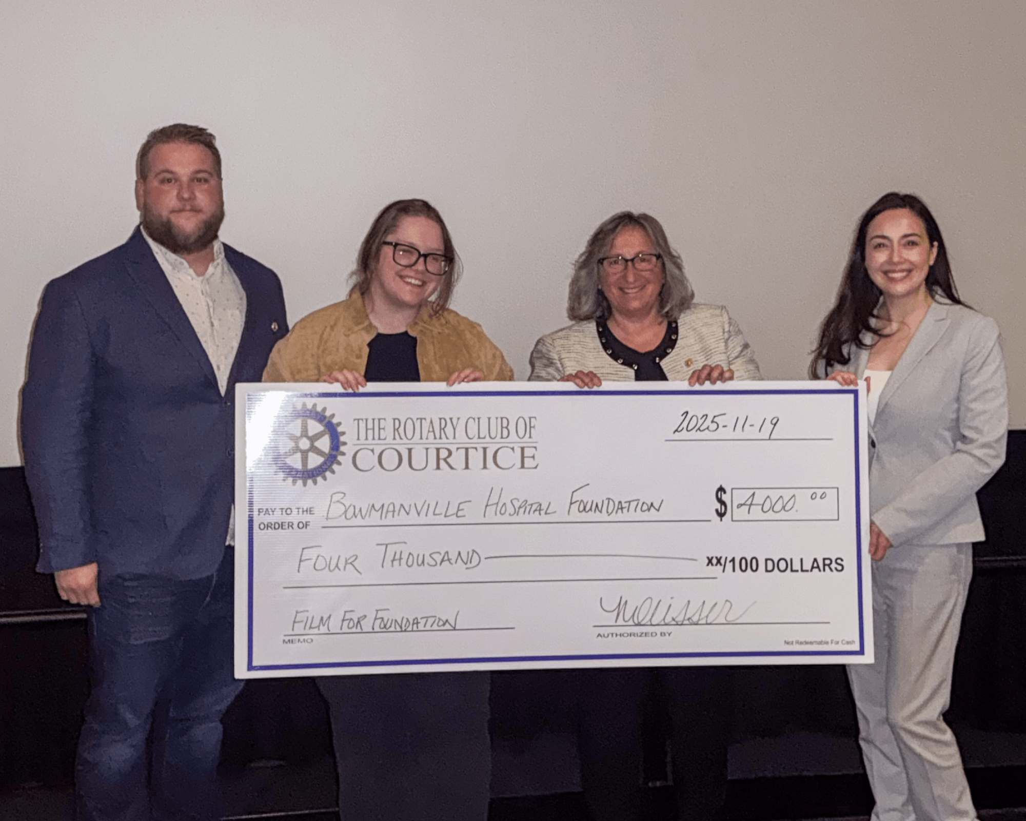 Four people holding up an oversized cheque from the Rotary Club of Courtice.