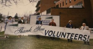 Six people standing outside of the Bowmanville Hospital with a sign that reads: "Thank You Volunteers."