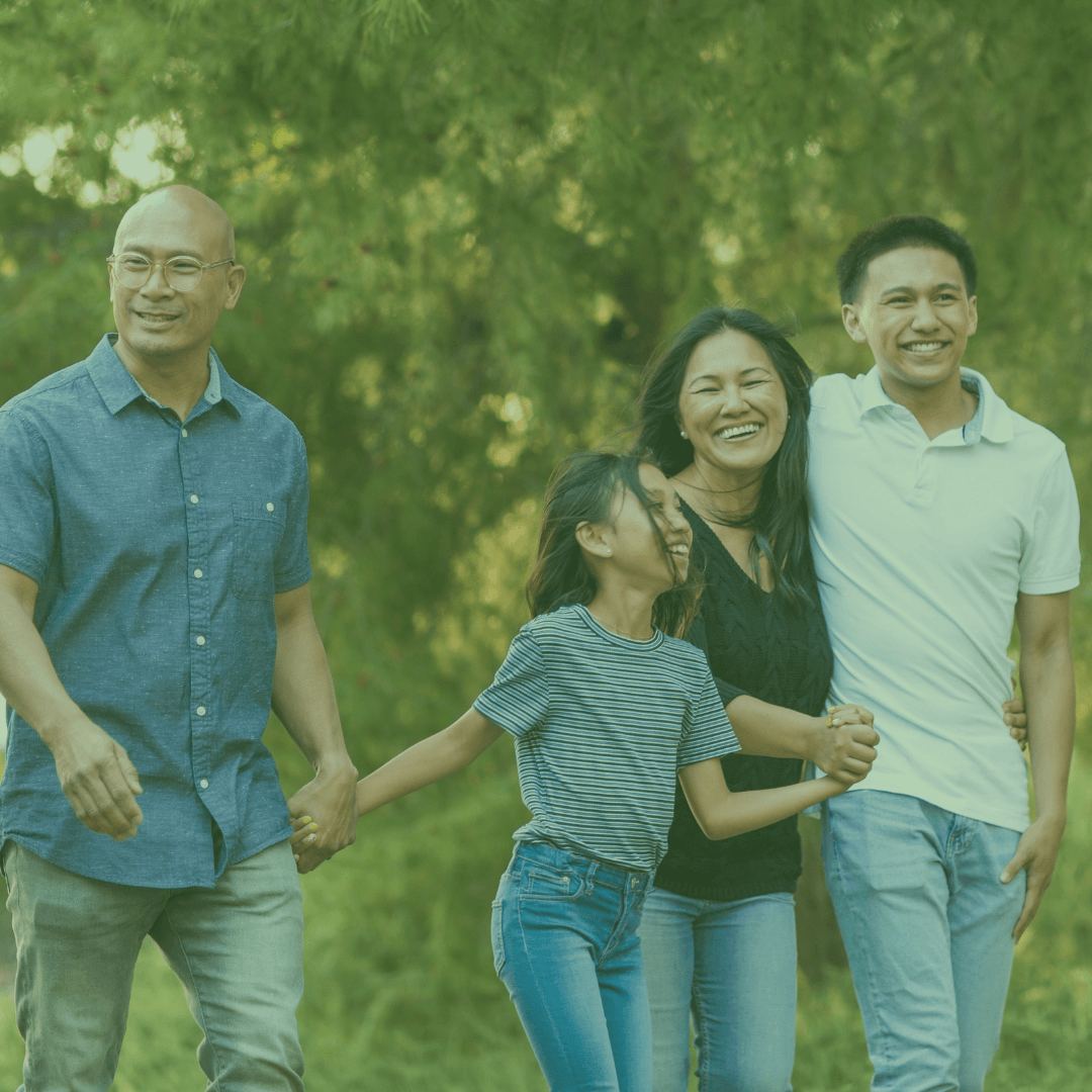 A family of four walking together in a forested area, with a green overlay.