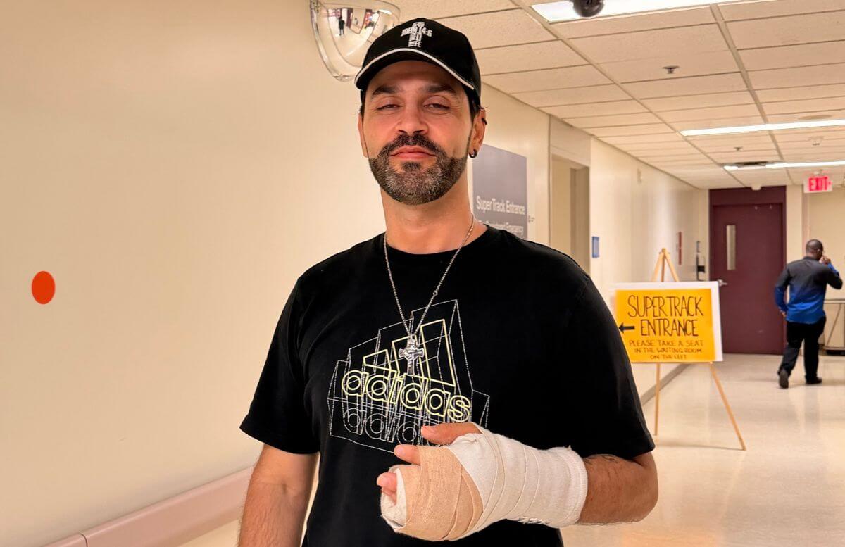 Chris standing in front of the super track entrance at Bowmanville Hospital with his arm in a cast.