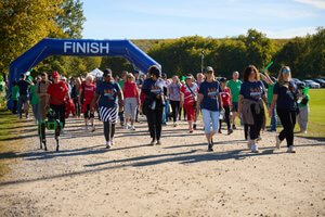 A large group of participants walking from the starting line on a gravel path.